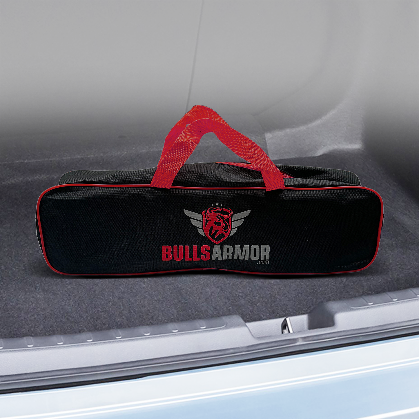 Black and red 'Bulls Armor' car safety hammer on a car's open trunk.