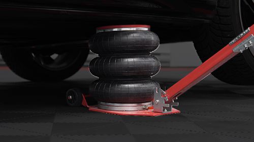 Car jack lifting a car with air bags on a dark background