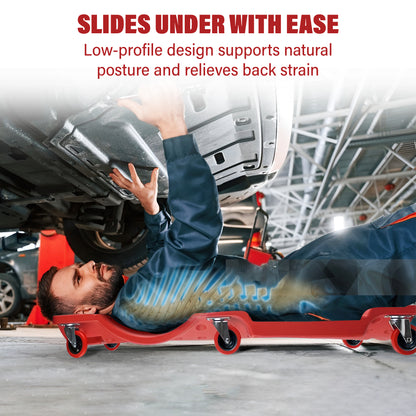 Person using a red mechanical slide under a vehicle in a garage setting.